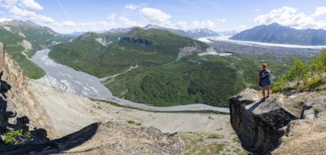 Panorama, young woman on a rocky outcrop enjoying the view, view of impressive mountain landscape