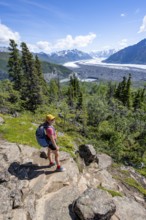 Young woman enjoying the view, view of impressive mountain landscape with Matanuska glacier and