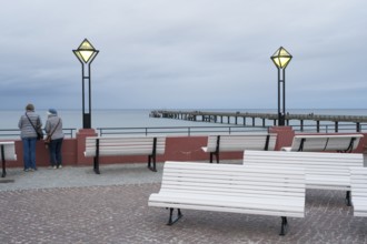 Kurplatz am spa hotel, two people from behind, pier and Baltic Sea behind, twilight, Binz, seaside