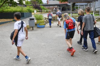 Group of children with school bags, outside on a path in front of school building, Lower Saxony,