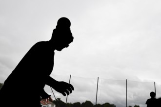 Silhouette of a person against cloudy sky, athletic posture, sports and fun Olympics Sportfest