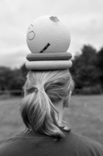 Person with ball and wrestling on head, environment in nature, sports and fun Olympics sports