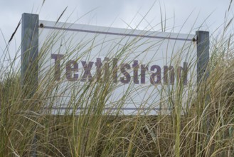 Beach oats in front of the textile beach sign, Baltic resort Göhren, Baltic Sea, Rügen island,