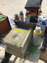 Lower Saxony, Germany, Unpainted birdhouse and brush with Ukrainian flag on a table with paints and