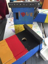 Lower Saxony, Germany, painted bird house in blue and yellow with flowers. Ukrainian students'