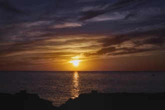 Colourful sunset over the sea with reflective, dramatic cloud formations, Playa Blanca Lanzarote