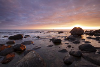 Rocky bay under a dramatic glowing sky at the coast. unset, Vigrestad, Rogaland, Norway