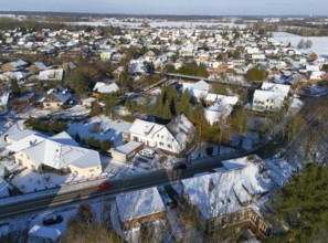Snowy residential area with houses, roads and trees under clear winter sky, Aerial View, Oelsburg,