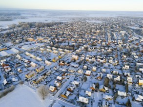 Snowy village landscape in evening light with numerous houses and roads, aerial view, Oelsburg,