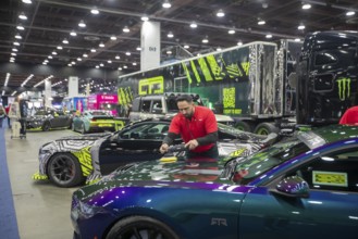 Detroit, Michigan USA - 14 January 2026 - A worker polishes a vehicle being displayed at the