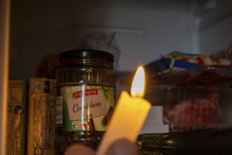 Blackout icon: Illuminating a dark refrigerator with a candle