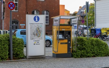Cash machine and signpost on the grounds of the Charite Campus in Berlin Mitte, Germany