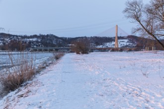 Niederwartha Elbe Bridge, cold winter morning on the Elbe with floating ice floes, snow and dawn at