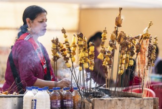 Vendor selling roasted meat at a stall in Bhogali Mela, ahead of the 'Magh Bihu' festival, in