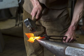 A blacksmith forging, working at the Ehnert forge in Dresden-Bühlau, Saxony, Germany