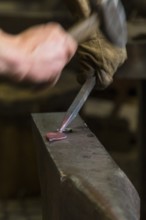 A blacksmith forging, working at the Ehnert forge in Dresden-Bühlau, Saxony, Germany