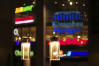 Night view, street lamps, neon lighting behind in blur, logo Mediamarkt, Tegut, Action, Subway,