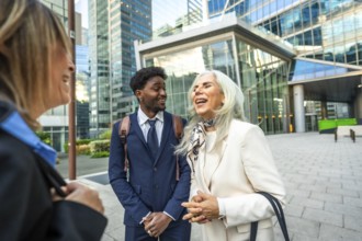 Diverse group of business people collaborating and laughing together during an outdoor meeting on a