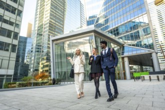 Diverse business professionals walking and discussing outdoors in a contemporary financial