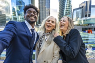 Diverse business professionals feeling happy and celebrating success while taking a selfie