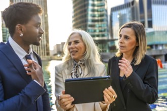 Multi ethnic group of business people collaborating and discussing new strategies using a digital