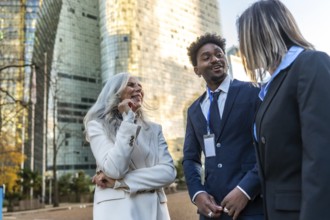 Diverse business professionals sharing a cheerful conversation and networking outdoors in an urban