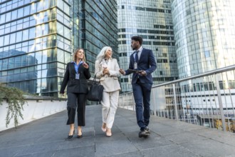 Diverse business professionals, including a senior woman, walking on an elevated walkway with