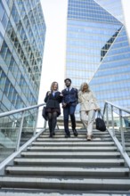 Diverse group of business people collaborating and walking down stairs in a modern financial