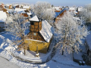 Snowy half-timbered church in wintry village against clear blue sky, aerial view, Old Chapel, 15th