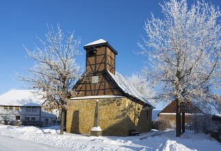 Snowy half-timbered church with blue sky and snow-covered trees in the background, Old Chapel, 15th