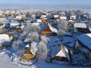 Winter village with snow-covered roofs and half-timbered buildings, cold, peaceful atmosphere,