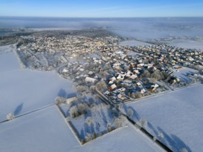 Winter aerial view of a village with snowy fields and clear blue sky, aerial view, partly fog,