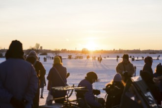 People sitting and standing at sunset on Tempelhofer Feld in Berlin on 11.01.2026