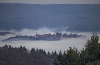 Aerial view of a medieval town, Dilsberg mountain fortress in a fog landscape in the Odenwald near