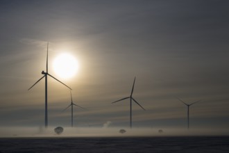 Wind turbines at sunset in a foggy winter landscape, wind turbines between Solschen and Adenstedt,