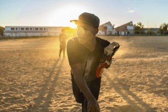 Young baseball player focusing while preparing to throw from the pitcher's mound, wearing a cap and