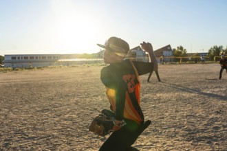 Young baseball player wearing a cap and jersey, preparing to throw the ball during a game on a