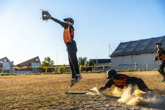 Baseball infielders making a critical play on a dusty field during a game, one player sliding into