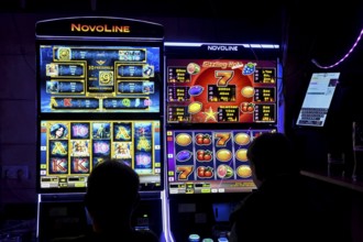 Guests at a pub in front of slot machines, Munich, Bavaria, Germany