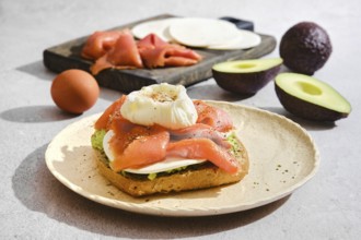 Toast topped with salmon, a poached egg, goat cheese and avocado. Sliced ingredients like salmon