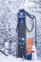 Snowy charging station for electric cars with clear energy figures, Tesla Model Y electric car,