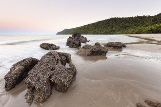 Scenic sunset view over the tropical coastline with calm ocean waves and golden light. Etty Bay