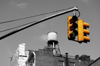 Yellow traffic light rear wooden water tank Downtown, New York City, USA
