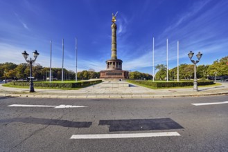 Victory column, roundabout, lantern, flagpoles, sidewalk, road, road markings lanes and direction