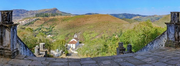Historic churches and mountains of the city of Ouro Preto seen through stone columns, Ouro Preto,