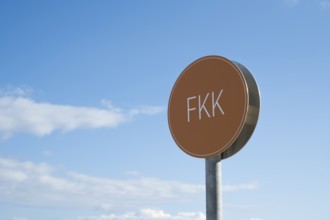 Naturist sign against blue sky with white clouds, Binz, seaside resort, Rügen island, Baltic Sea,