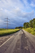 Landscape, road, high-voltage line, high-voltage mast, fields, trees, bushes, meadow, cloudy,