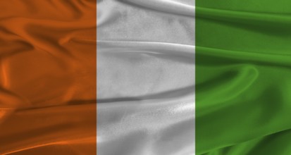 Flag of Ivory Coast with fabric textured background. Close up of National flag of Ivory Coast with