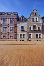 Historic residential buildings, façade with windows, gables and tail gables, paving street, blue