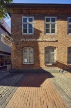 Eckernförde Museum, pedestrian zone, brick building, façade with windows, paving and paving stones